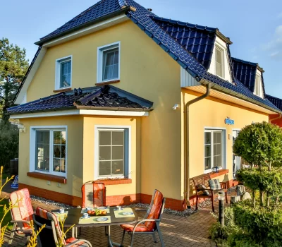 Außenansicht des Ferienhauses Seeadler in Zingst mit Terrasse und Sitzplatz im Garten.