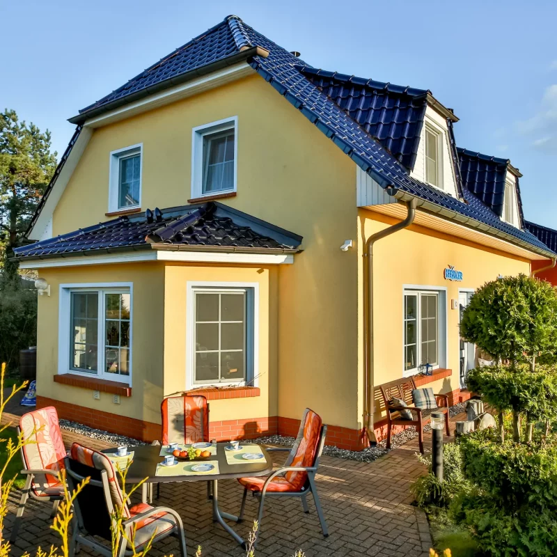 Außenansicht des Ferienhauses Seeadler in Zingst mit Terrasse und Sitzplatz im Garten.